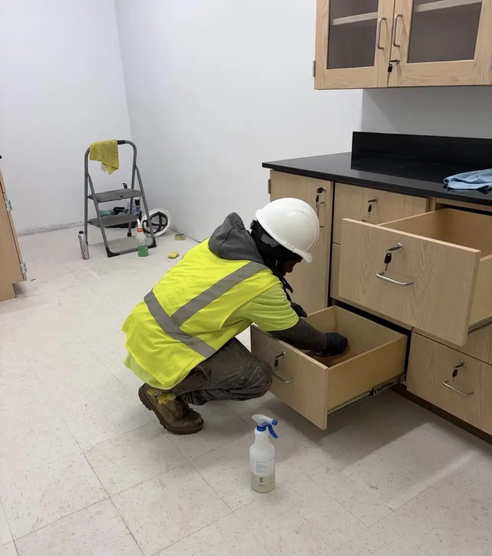 Legally Clean crew member wiping down new casework in a school lab